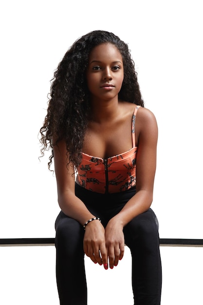 Free photo black woman with curly hair is sitting