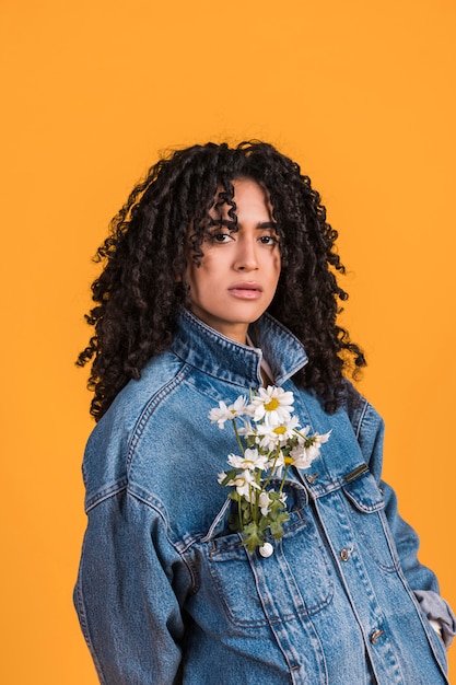 Black woman with daisy flowers in jacket pocket