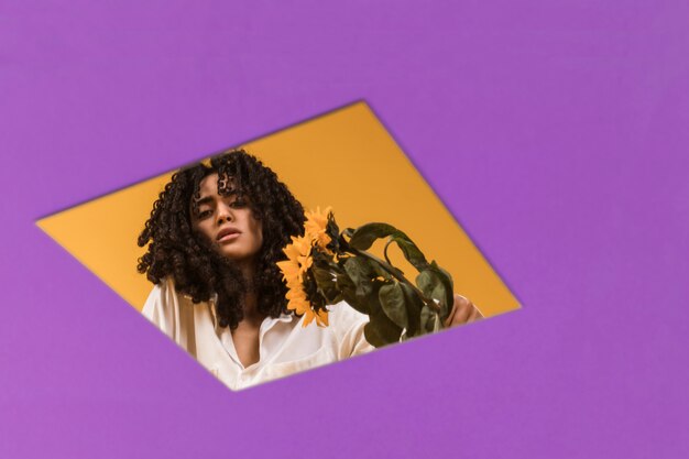 Black woman with flowers in hole in paper