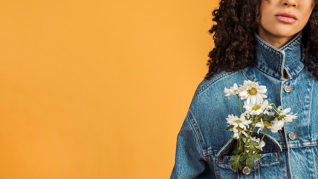 Free photo black woman with flowers in jacket pocket