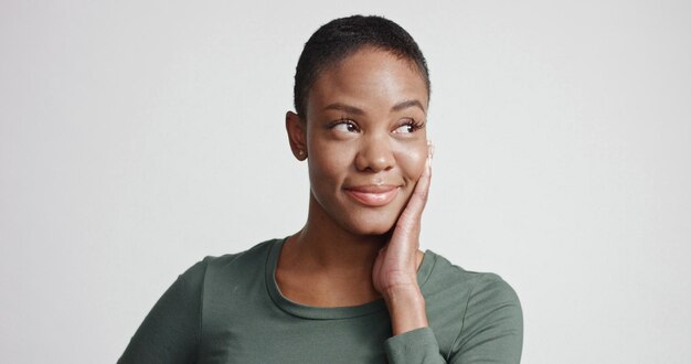 Black woman with a short haircut in studio shootsmiling and wearing dress