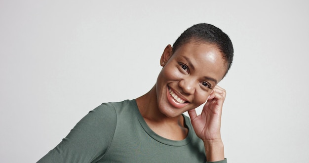 Black woman with a short haircut in studio shootsmiling and wearing dress