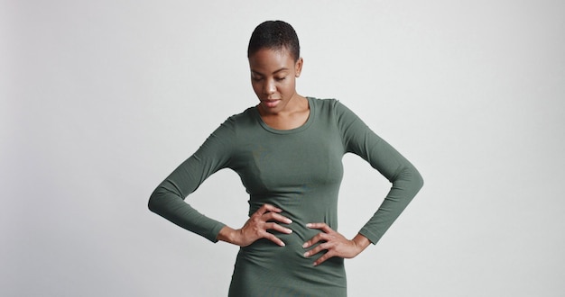 Black woman with a short haircut in studio shootsmiling and wearing dress