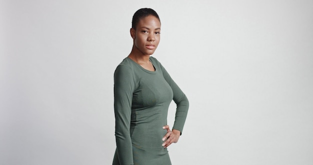 Black woman with a short haircut in studio shootsmiling and wearing dress