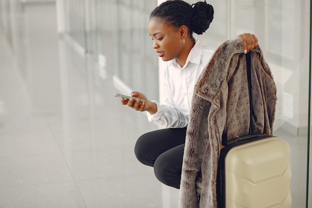 Donna di colore con la valigia in aeroporto