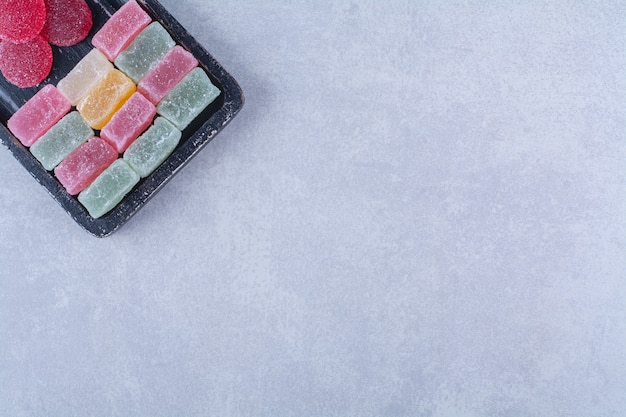 A black wooden board full of sugary colorful candies