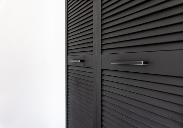 Black wooden wardrobe decorated with blinds, wardrobe with blinds decoration.