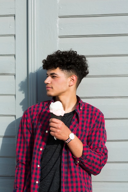 Black young man in checkered shirt holding ice cream 