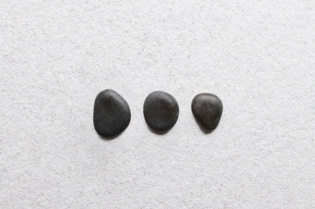 ウェルネスの概念で白い背景の上に積み重ねられた黒い禅の石