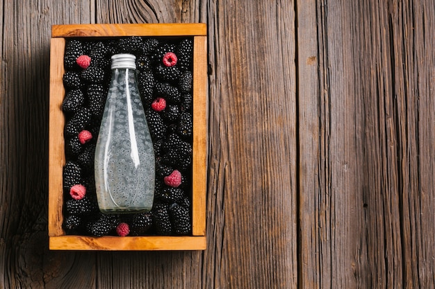 Blackberry juice bottle on wooden background