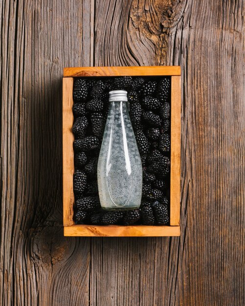 Blackberry juice bottle on wooden background