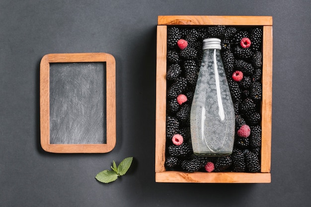 Blackberry juice bottle on wooden box copy space