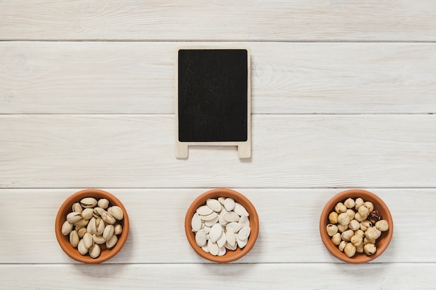 Blackboard and bowls with nuts and seeds