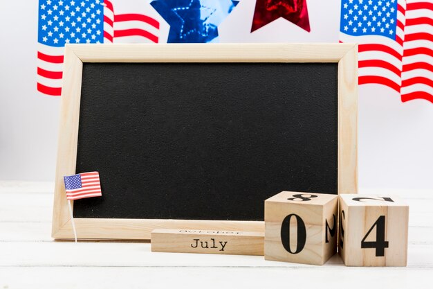 Blackboard decorated with small USA flag on Independence Day