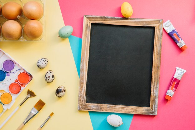 Blackboard and eggs on colorful background