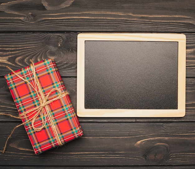 Free photo blackboard mock-up with christmas gift