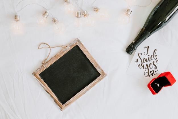 Blackboard near engagement ring and wine