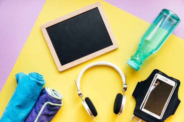 Blackboard near smartphone and bottle with towels