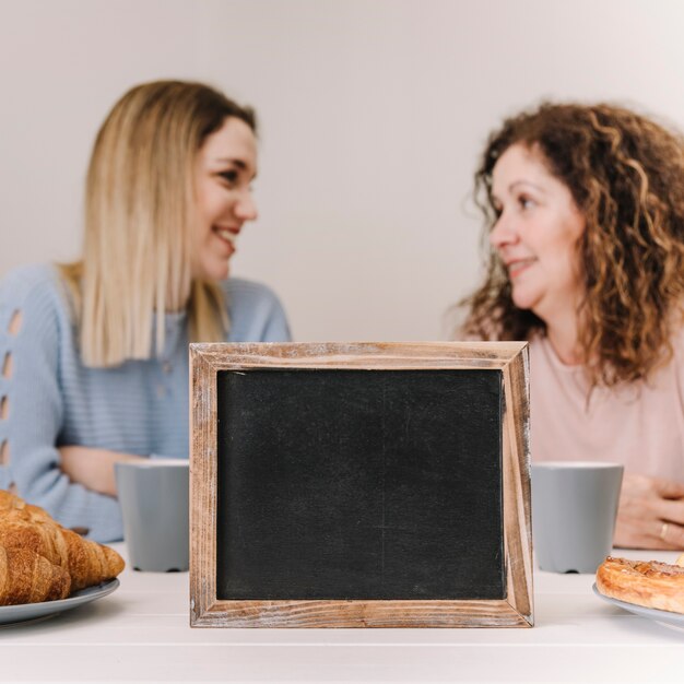 Blackboard near smiling mother and daughter