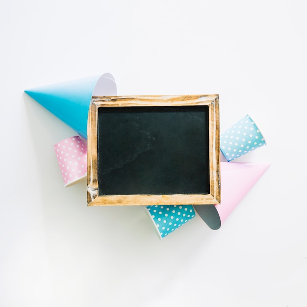 Free photo blackboard on party hats and cups