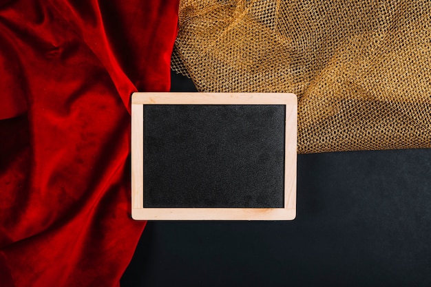 Blackboard on red and golden fabrics