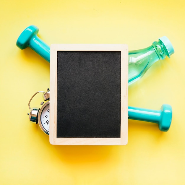 Blackboard on sportequipment and alarm clock