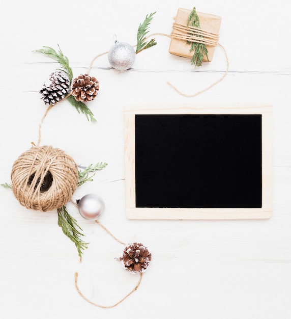 Free photo blackboard surrounded by christmas packing decorations