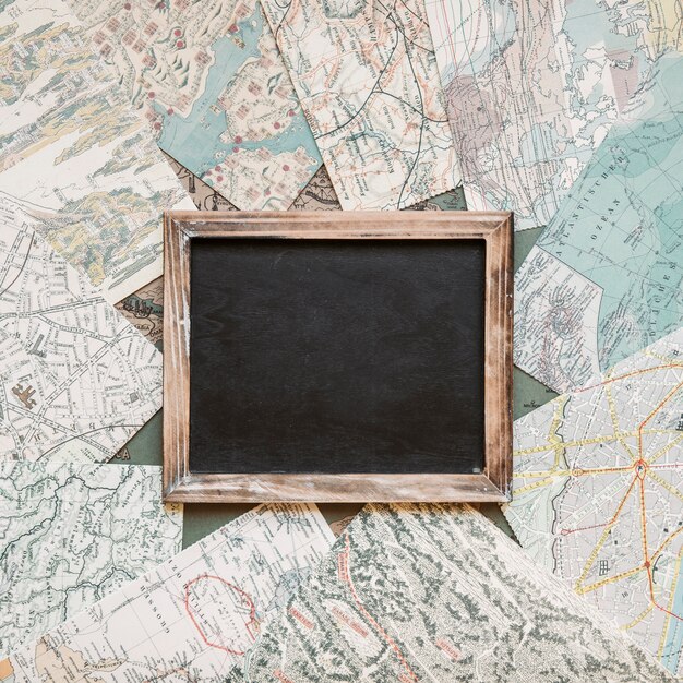 Blackboard on table with maps