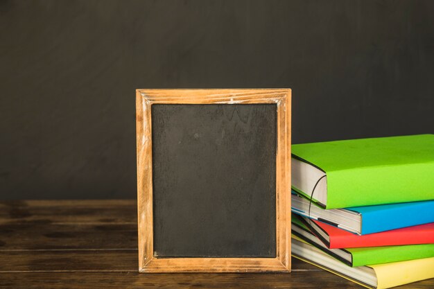 Blackboard with books on table