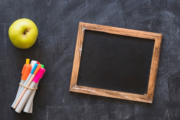 Blackboard with frame markets and apple