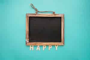 Free photo blackboard with happy lettering