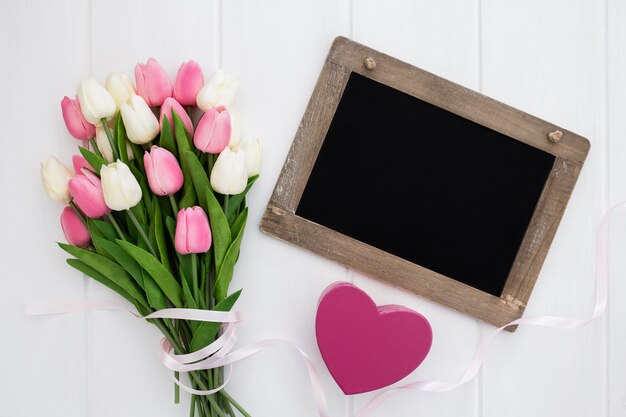 Blackboard with heart and bouquet of tulips 