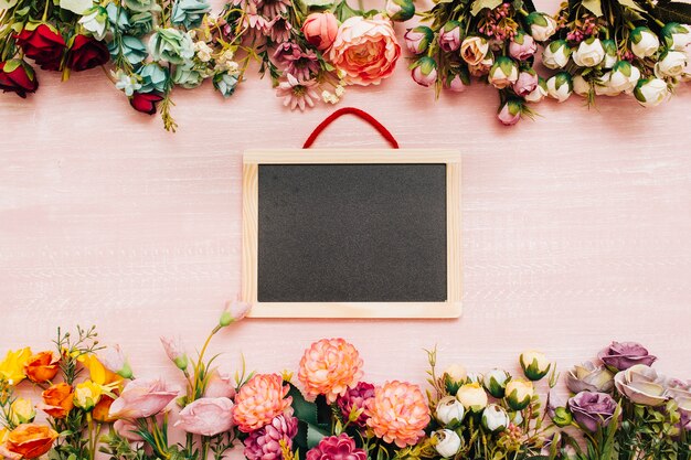 blackboard on wooden background with flowers