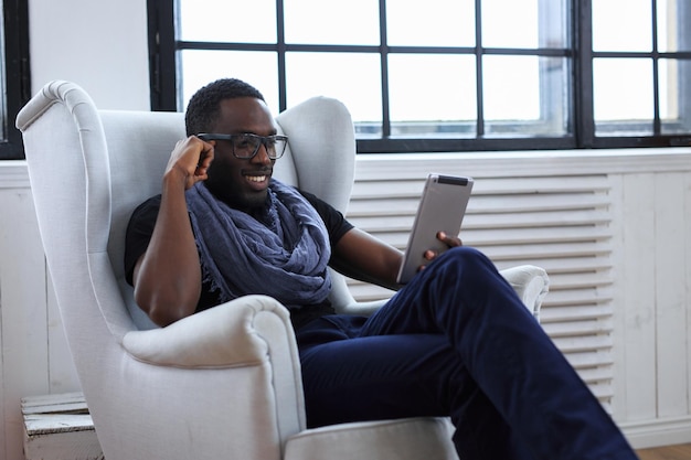 Blackman in eyeglasses working with table pc.