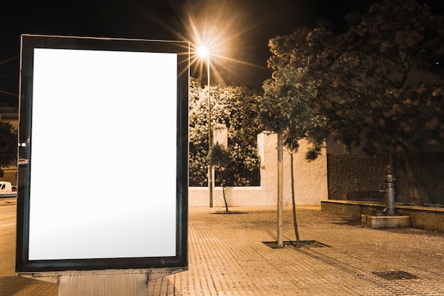 照明された街灯の近くの空白の広告看板