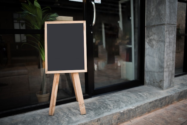 Blank black chalk board in front of the cafe