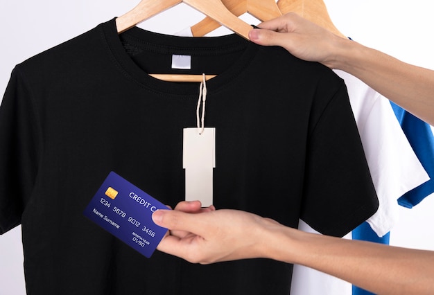 Бесплатное фото Пустая черная футболка и метка для рекламы. рука кредитной карты для покупки рубашки.