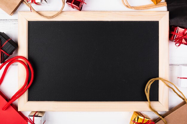 Blank blackboard surrounded by gift bags