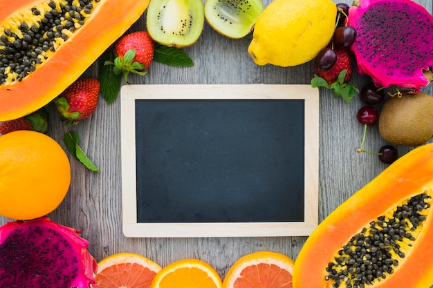 Blank blackboard surrounded by summer fruits