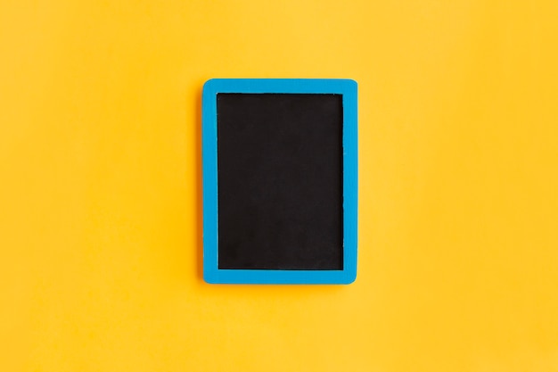 Free photo blank blackboard  with blue wooden frame on yellow