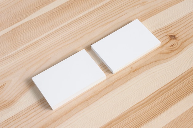Blank business card stacs on old wooden desk. Template to showcase your presentation.
