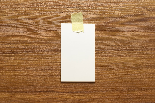 Blank business cards glued with yellow tape on a wooden surface and free space, 3.5 x 2 inches size