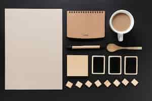 Free photo blank card; diary; tea cup; spoon; sticky note; cards and blocks on black background