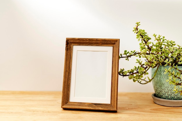 Blank decorative picture frame on wooden table