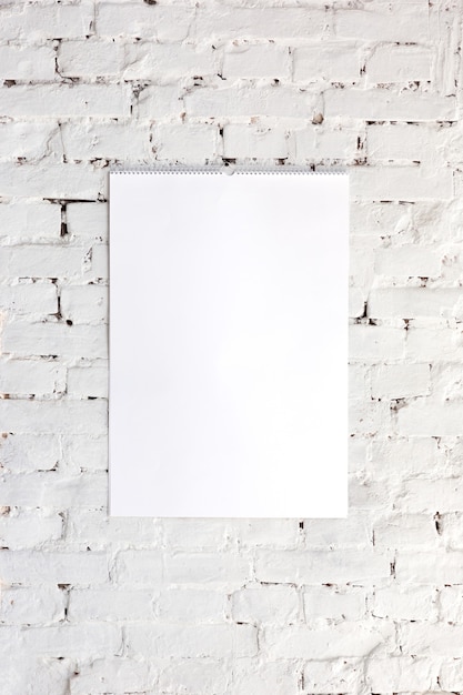 blank empty picture or sheet on the white brick wall . Copyspace, negative space for your advertising.