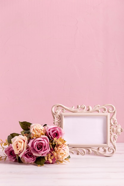 Free photo blank frame and beautiful rose bouquet