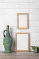 Free photo blank frame collection on wall and next to flagon