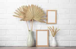 Free photo blank frame collection on wall and next to vase