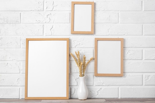Blank frame collection on wall and next to vase