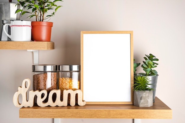 Blank frame next to flower pot and jar with condiments